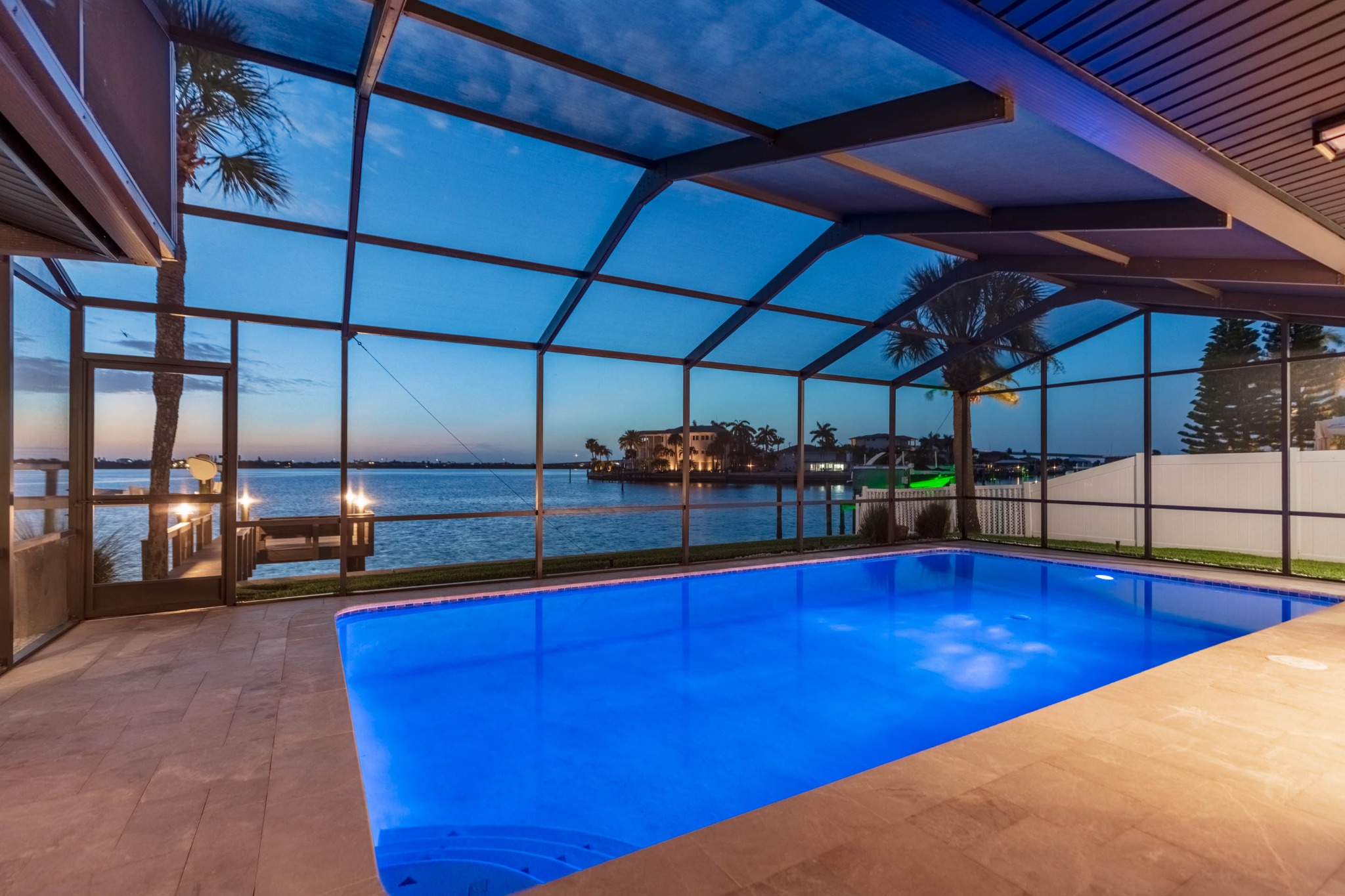 Pool, illuminated dock and open water at twilight